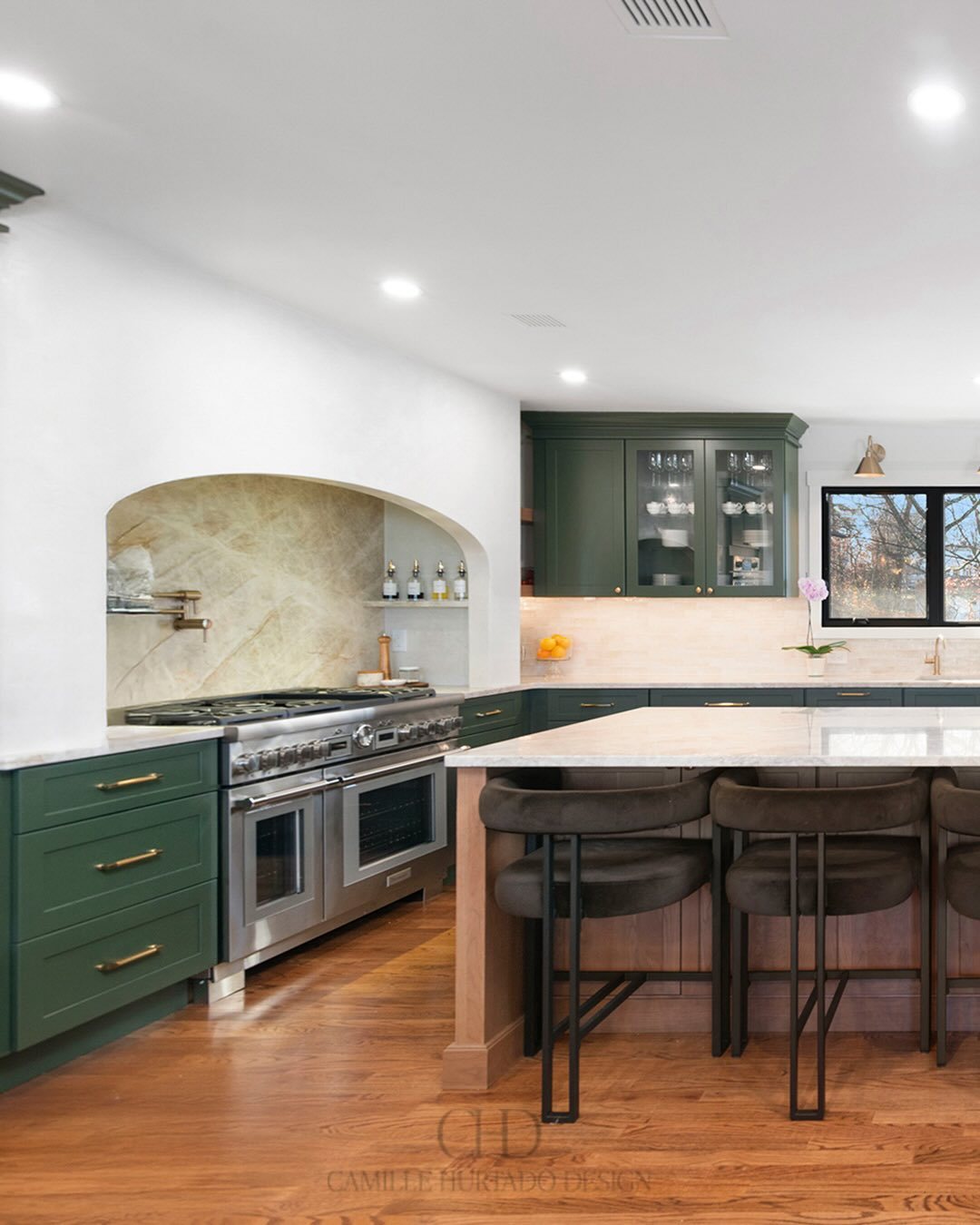 Green kitchen with marble arch and oak island
